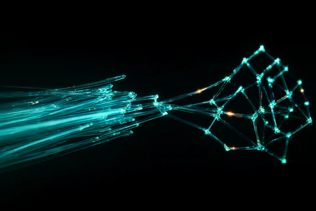 Haces de fibra óptica luminosa que se entrelazan formando una red neuronal con chispas naranja